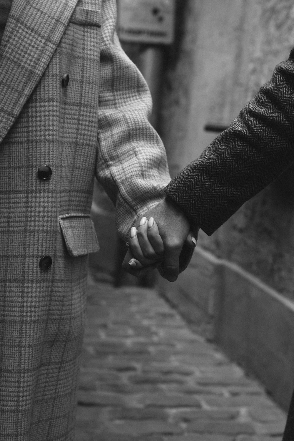 grayscale photo of man in coat holding cigarette stick