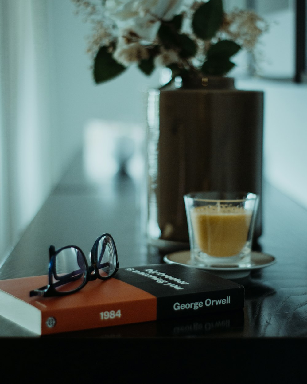 clear glass mug with brown liquid on brown wooden table