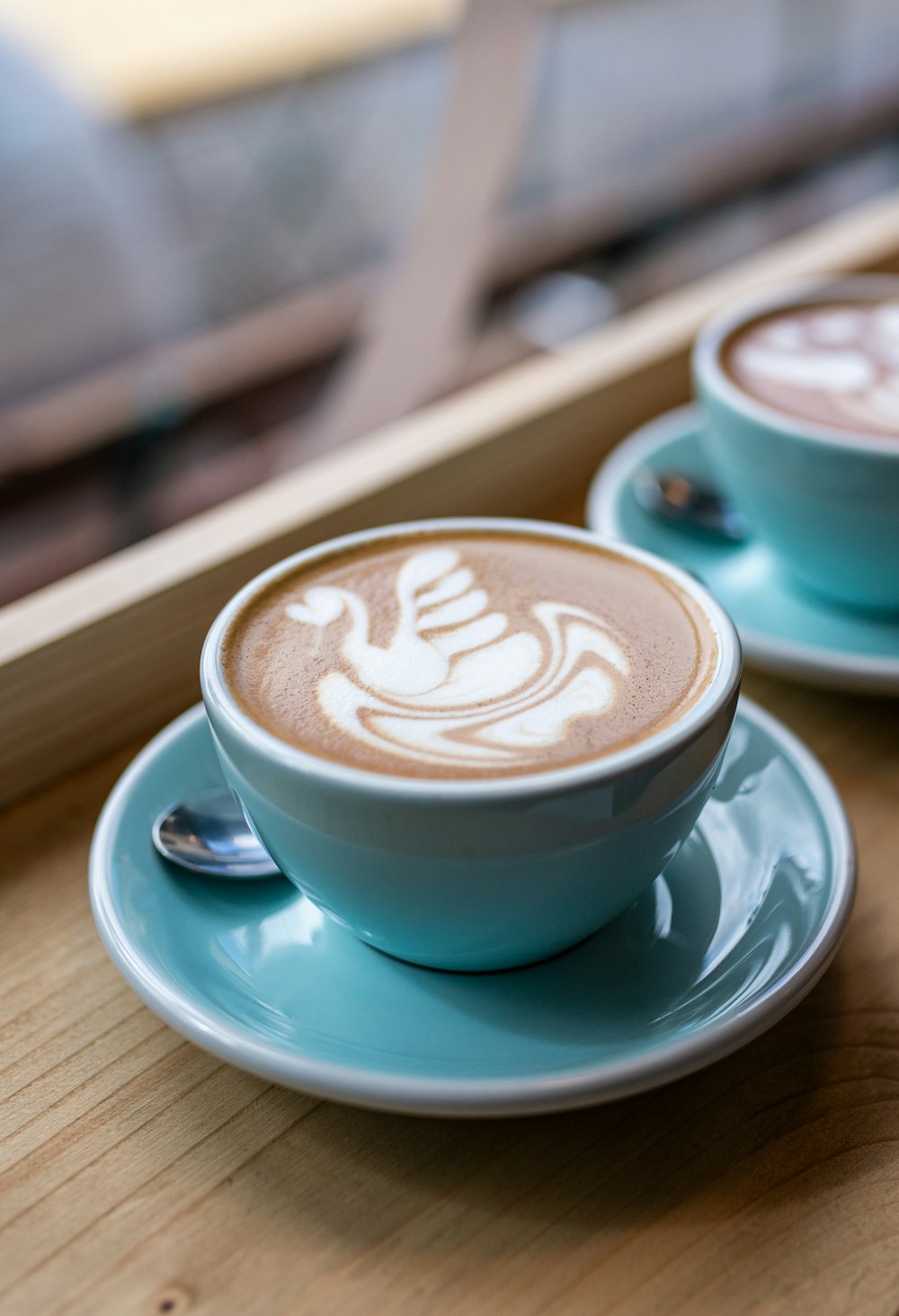 Tasse en céramique blanche avec soucoupe sur table en bois brun