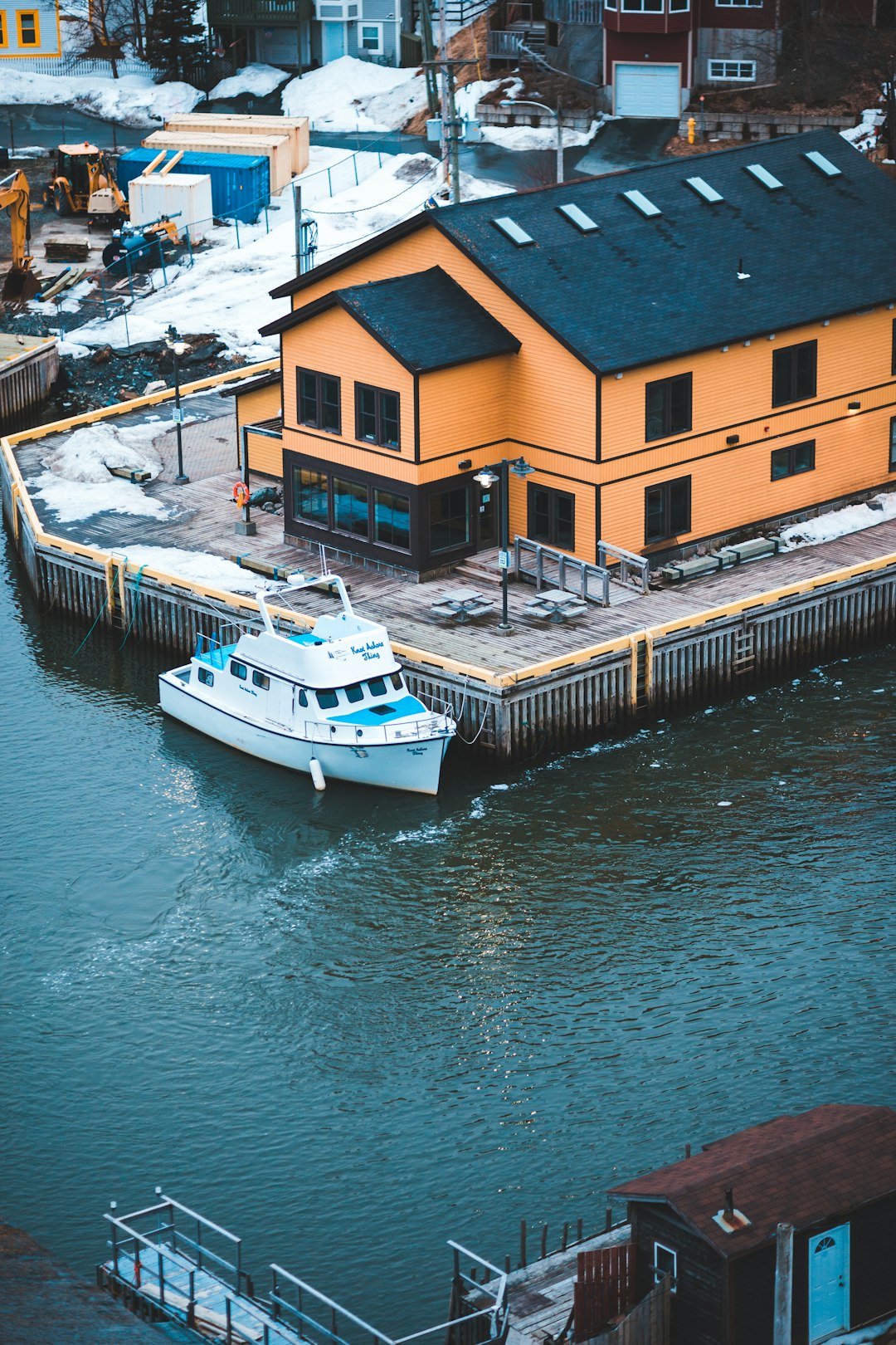 white boat on dock near houses during daytime