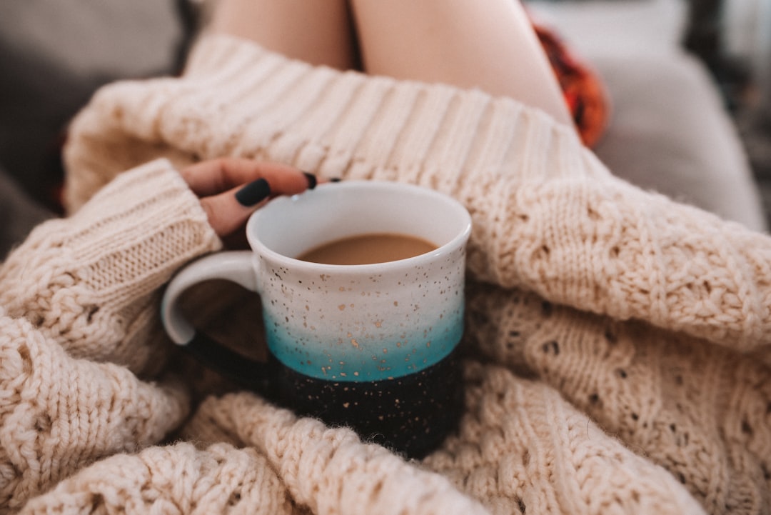 white ceramic mug on white knit textile,