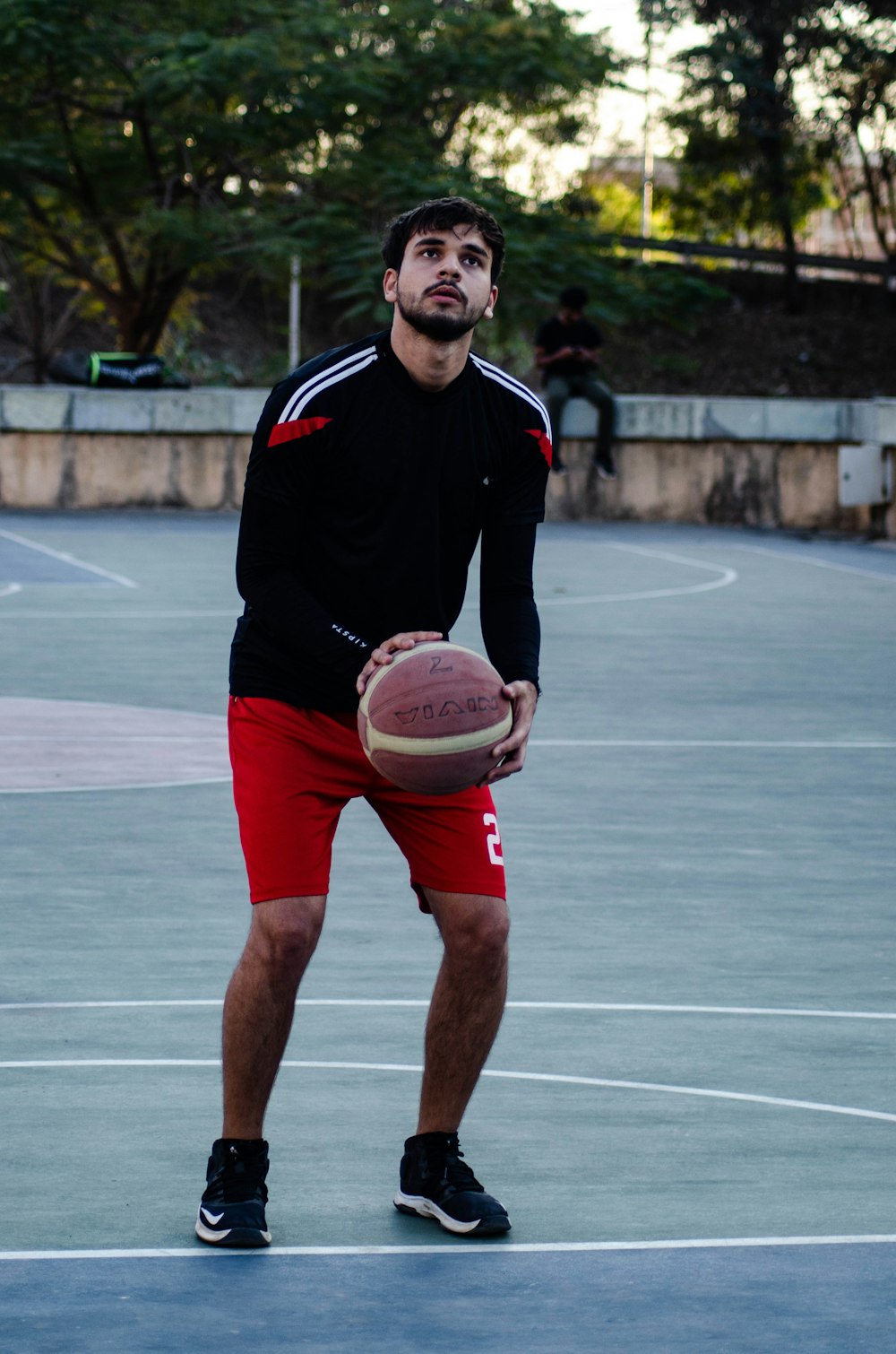 Foto Hombre con camiseta negra y roja de nike sosteniendo baloncesto blanco  y marrón – Imagen Humano gratis en Unsplash