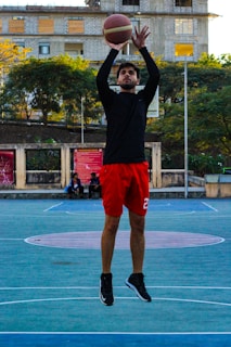 Basketball player mid-jump shot during a university game