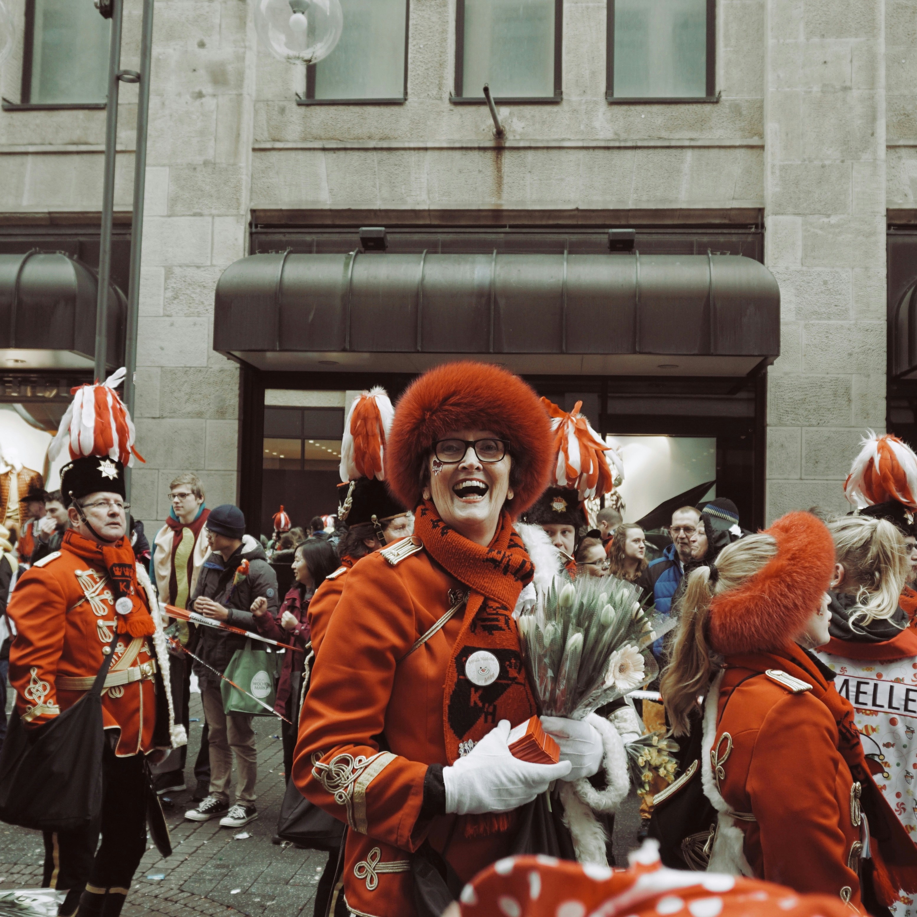 people in red and gold costume standing near building during daytime