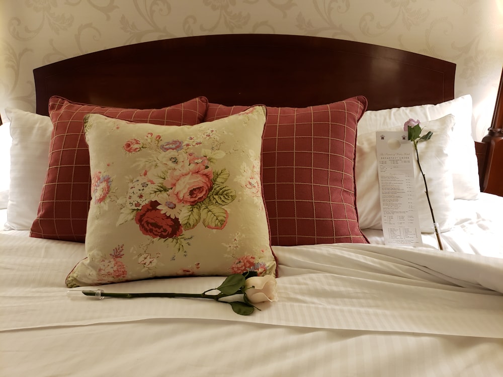 흰색과 분홍색 꽃 베개 흰색 침대에 베개