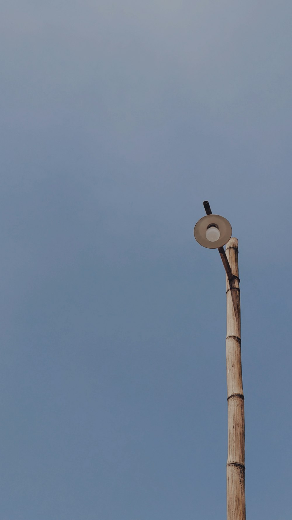 brown wooden post with white round light during daytime