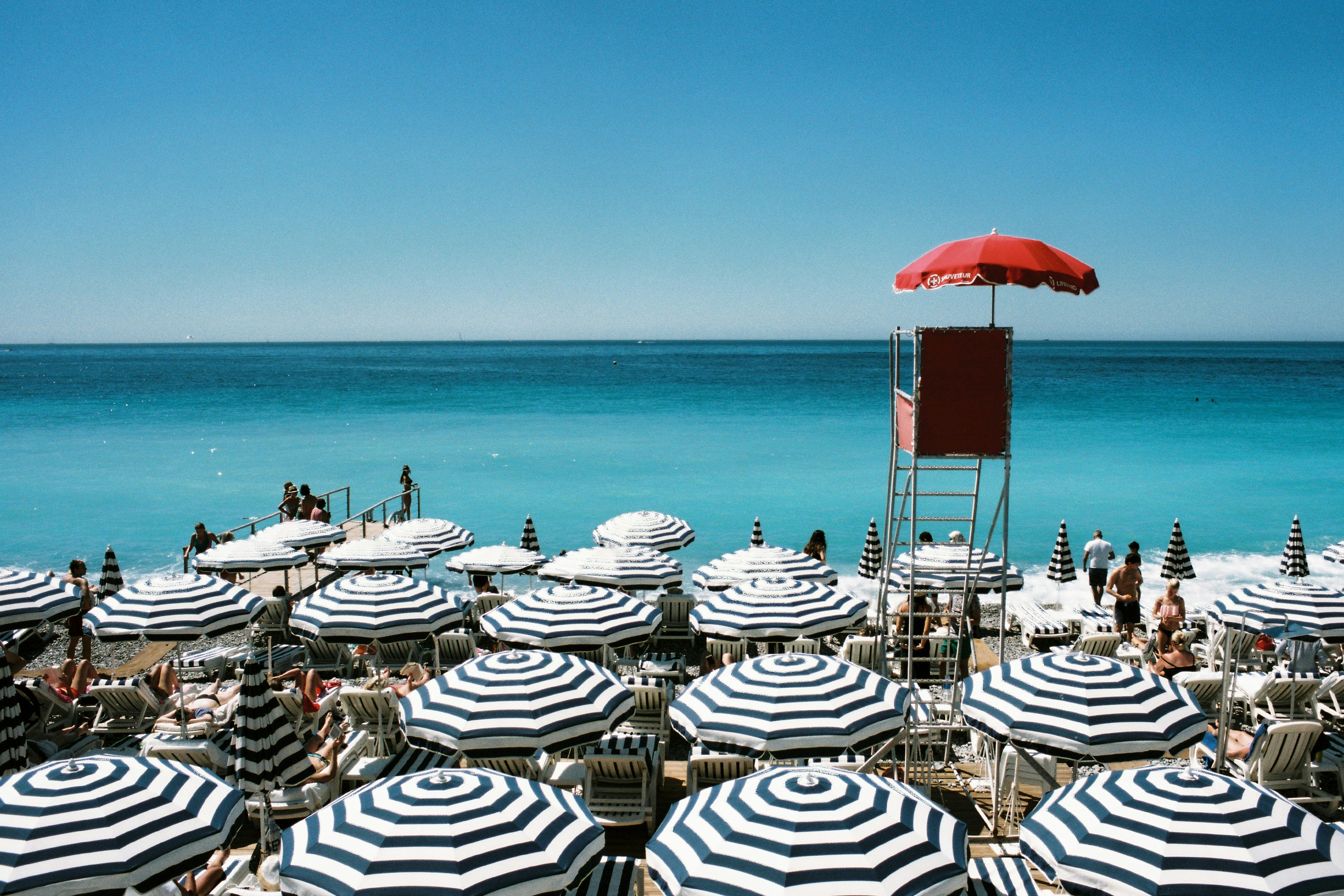 white and blue beach umbrellas on beach during daytime nice teams background
