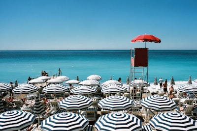 white and blue beach umbrellas on beach during daytime nice teams background