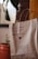A brown paper bag with handwritten text and a purple heart on it. The text is in Portuguese, expressing well wishes for the weekend. The bag is labeled with 'CAIPORA & DALILA' in blue ink. There's an orange pot holding a green plant in the background.