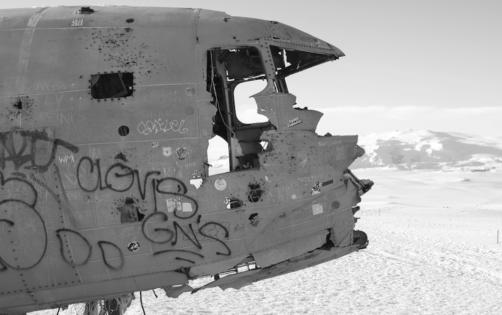 grayscale photo of wrecked car on beach