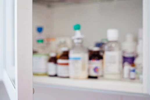Close-up of assorted veterinary medicines on a wooden counter inside a pet pharmacy.
