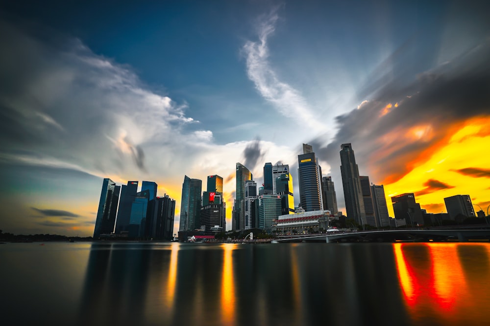 city skyline across body of water under cloudy sky during daytime