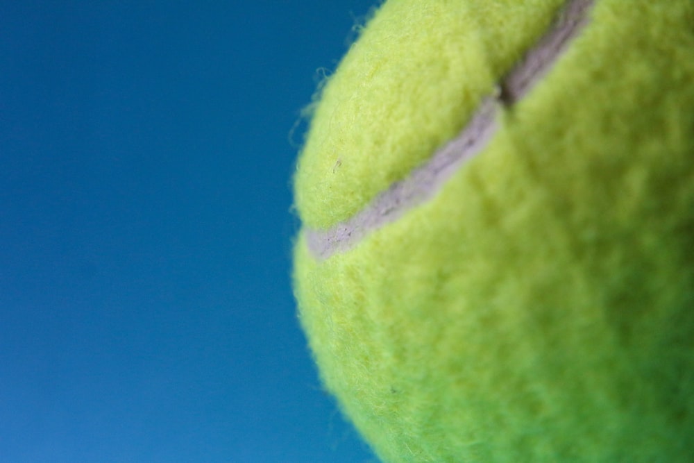 green tennis ball on blue textile