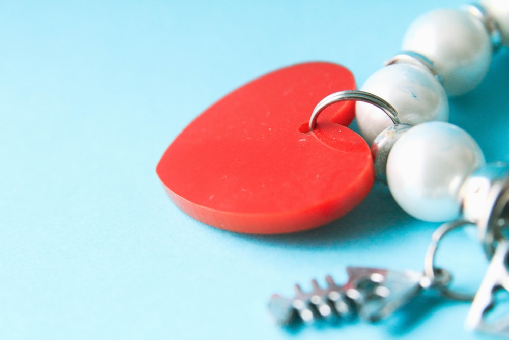 red heart shape keychain on white surface