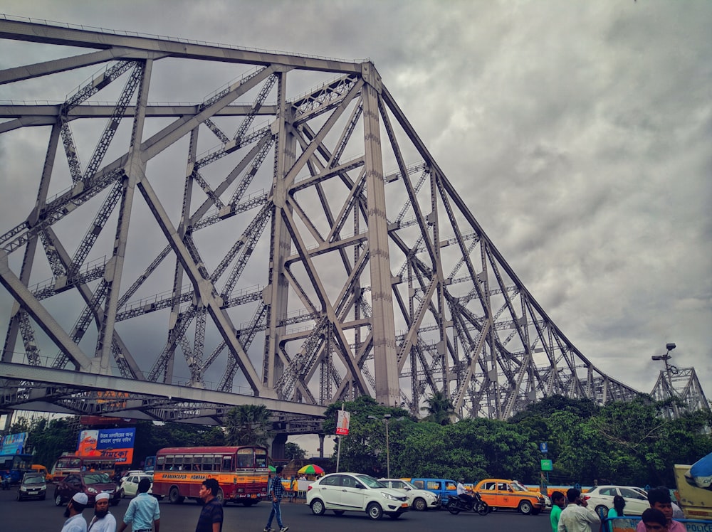 cars on gray bridge under gray cloudy sky during daytime