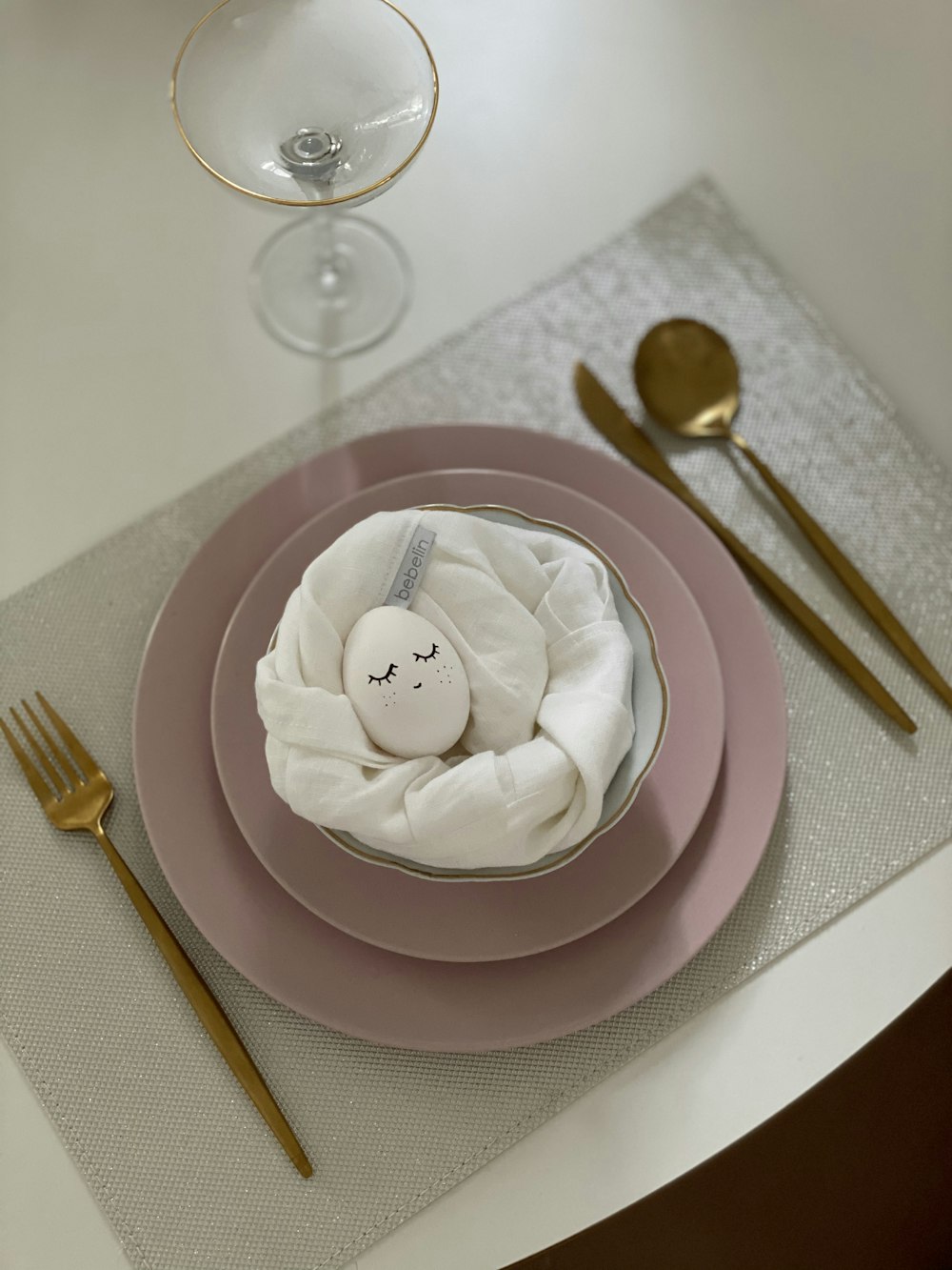 white egg on pink round plate beside fork and bread knife