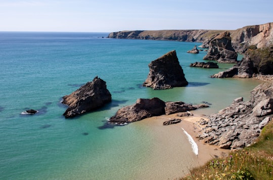 brown rock formation on blue sea water during daytime in Saint Agnes United Kingdom