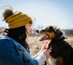 A happy dog and owner walking together, both adorned with coordinating gemstone accessories.