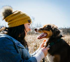 A happy dog and owner walking together, both adorned with coordinating gemstone accessories.