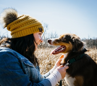 A mother and her pet wearing matching crochet accessories outdoors.