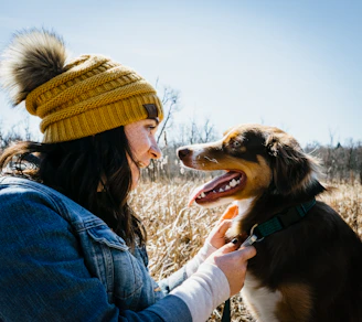 A cheerful dog and cat wearing colorful handmade clothes, posing happily together.