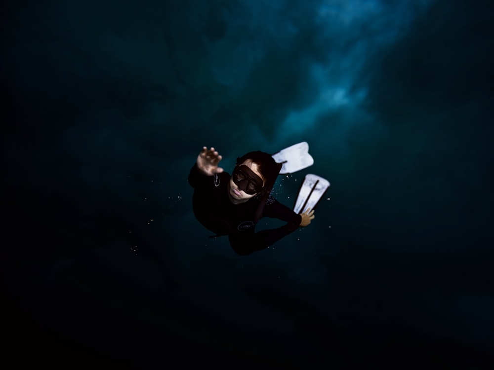 a man in a wet suit holding a surfboard under his arm