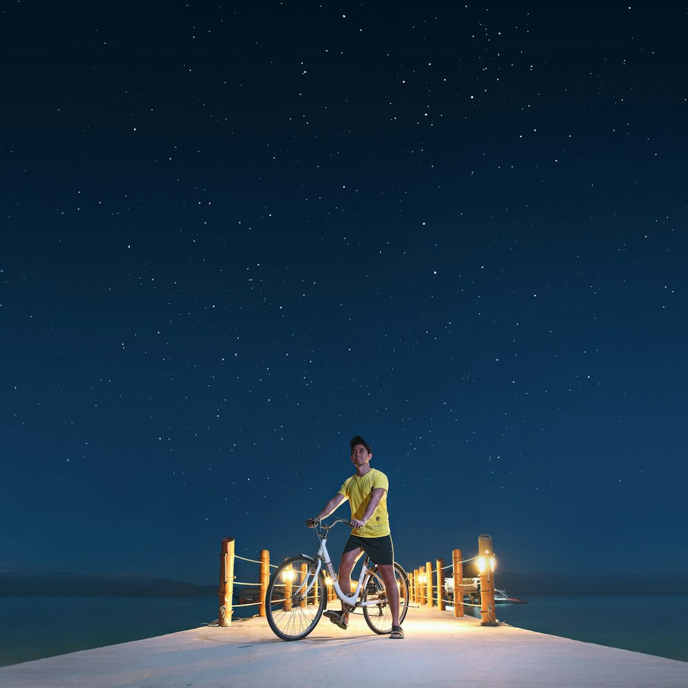 man in yellow shirt riding bicycle during night time