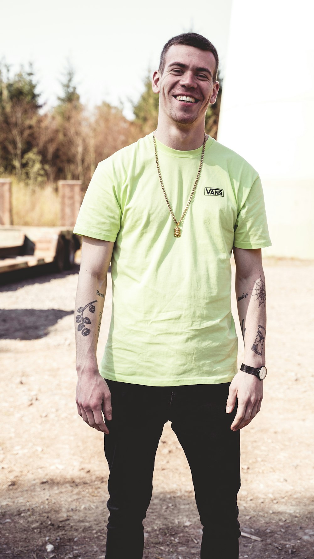 man in green crew neck t-shirt and black pants