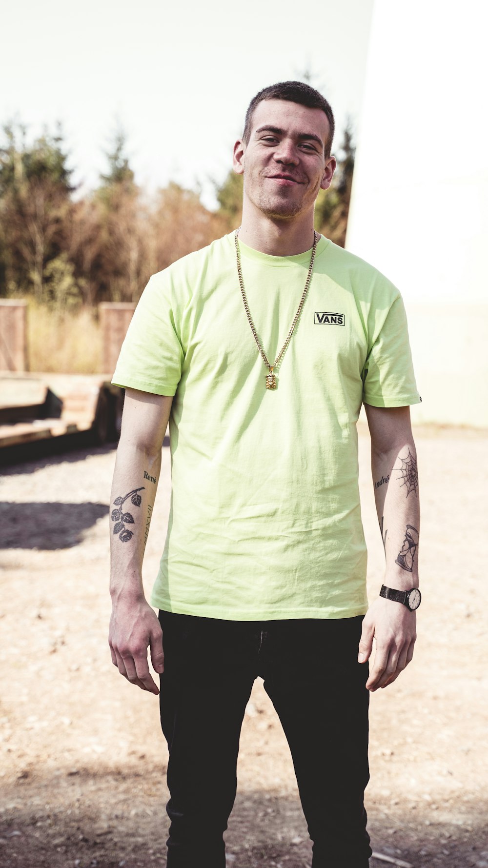 man in green crew neck t-shirt and black pants