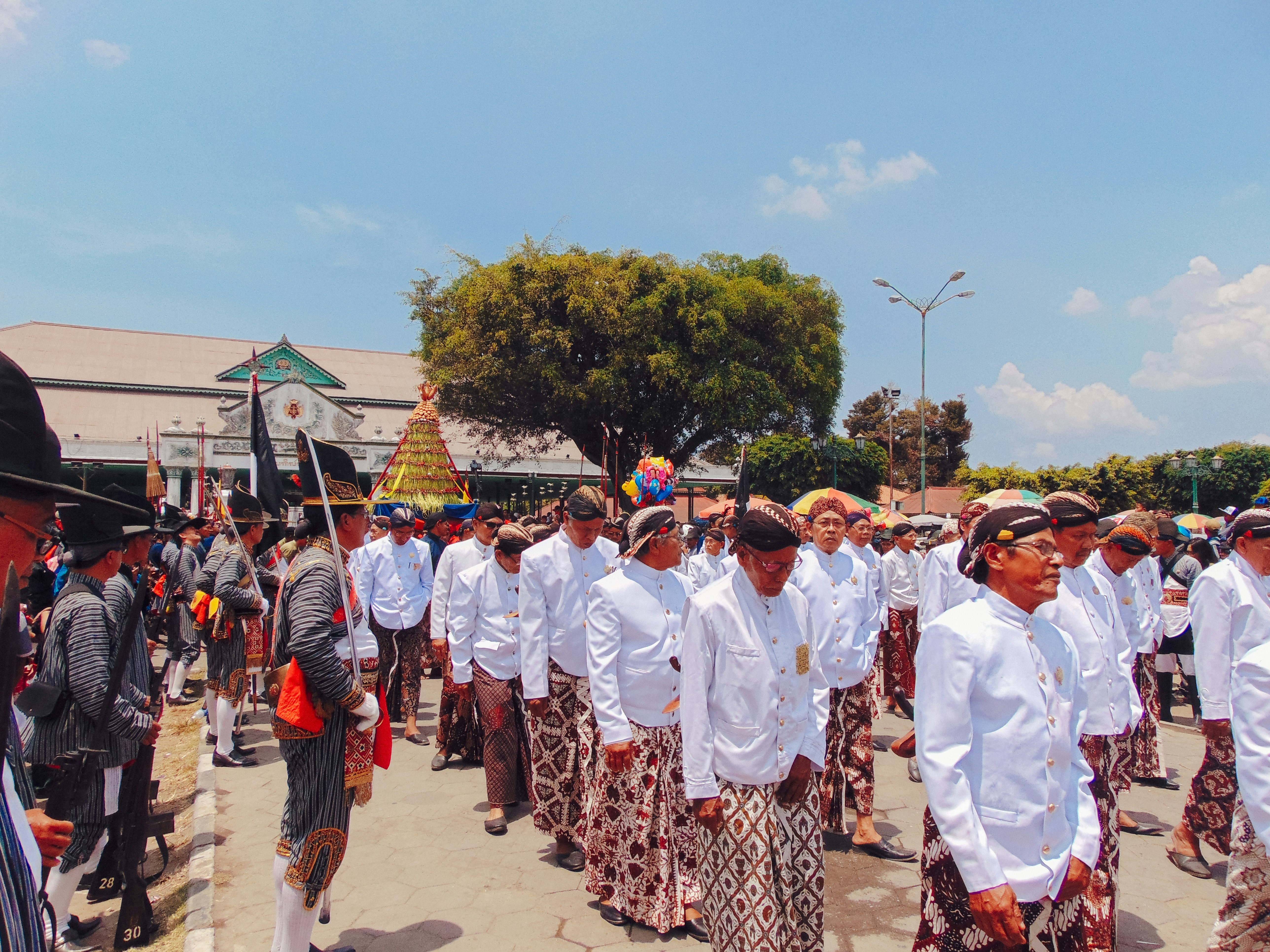 people in white uniform standing on brown sand during daytime