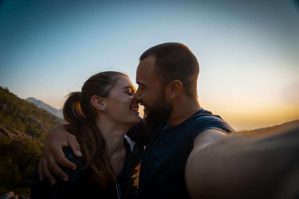 man and woman kissing under blue sky during daytime