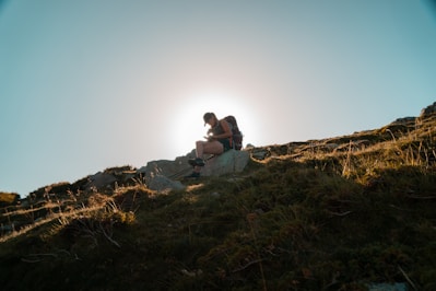 man and woman sitting on brown rock during daytime