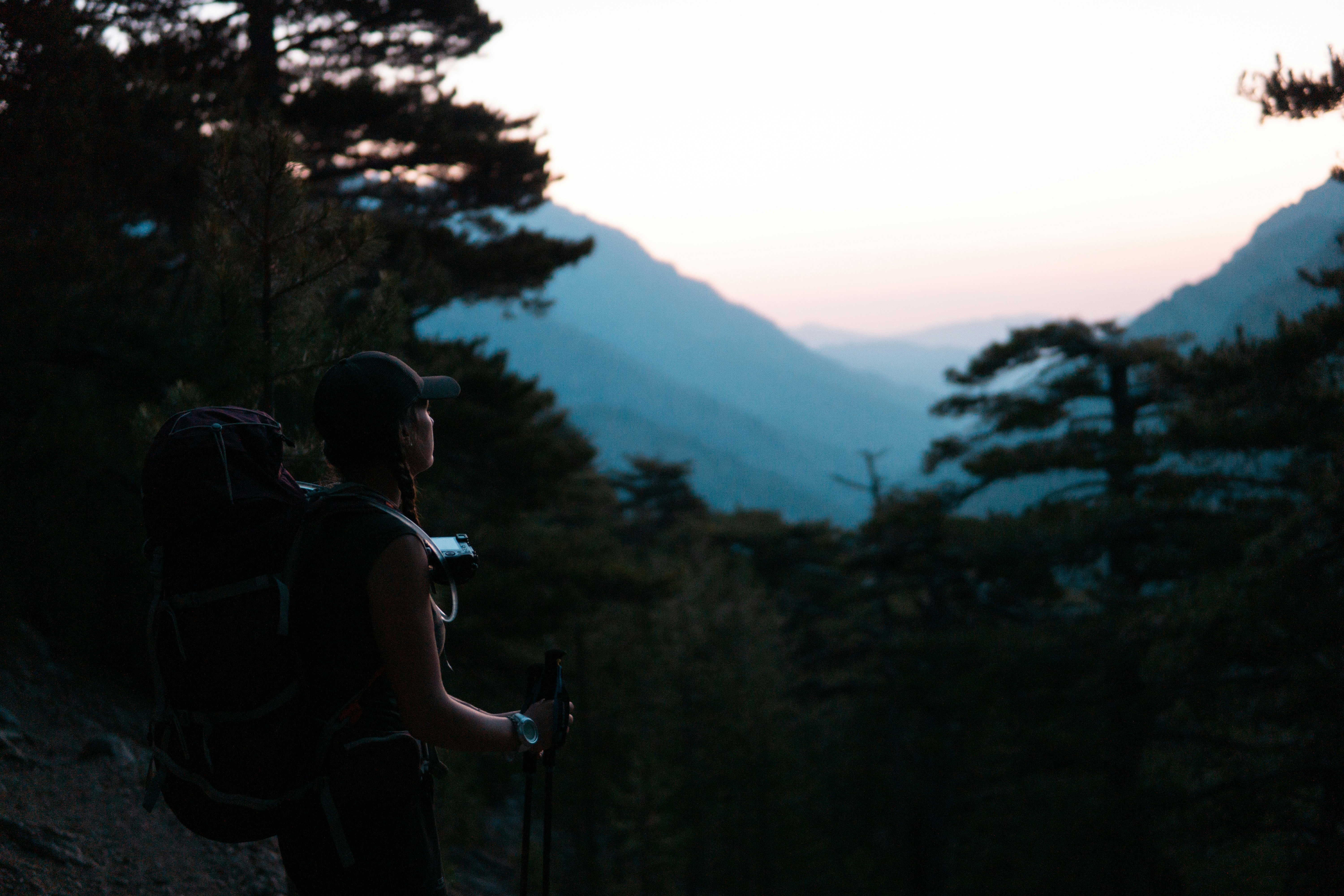 man in black and gray backpack standing on rock formation during daytime
