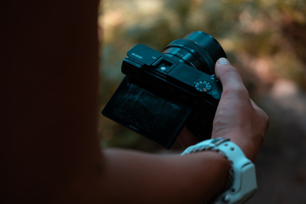 person holding black dslr camera