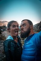 man in blue jacket beside woman in black and white floral shirt