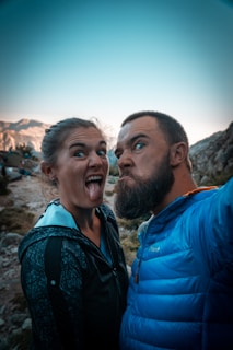 man in blue jacket beside woman in black and white floral shirt