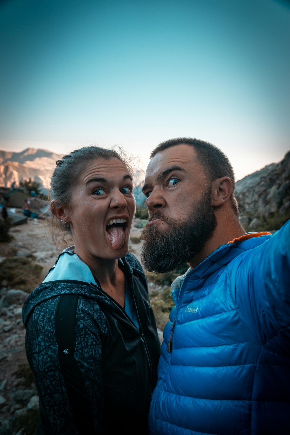 man in blue jacket beside woman in black and white floral shirt