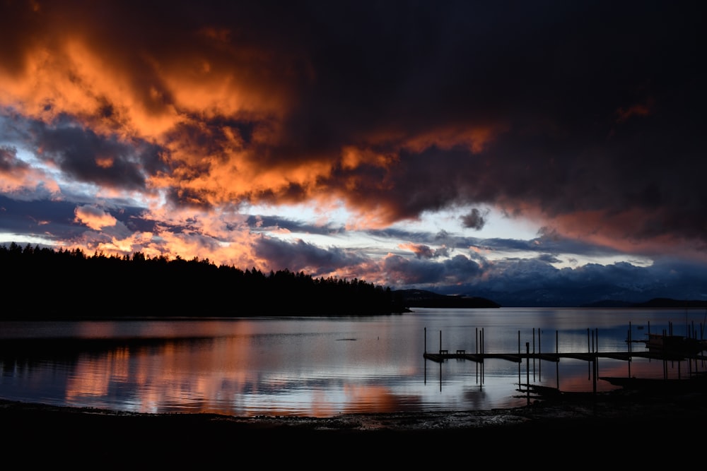 body of water under cloudy sky during sunset