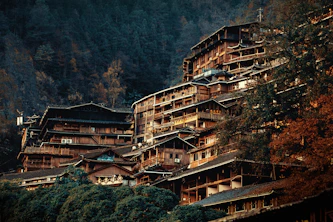 brown and white concrete building near green trees during daytime
