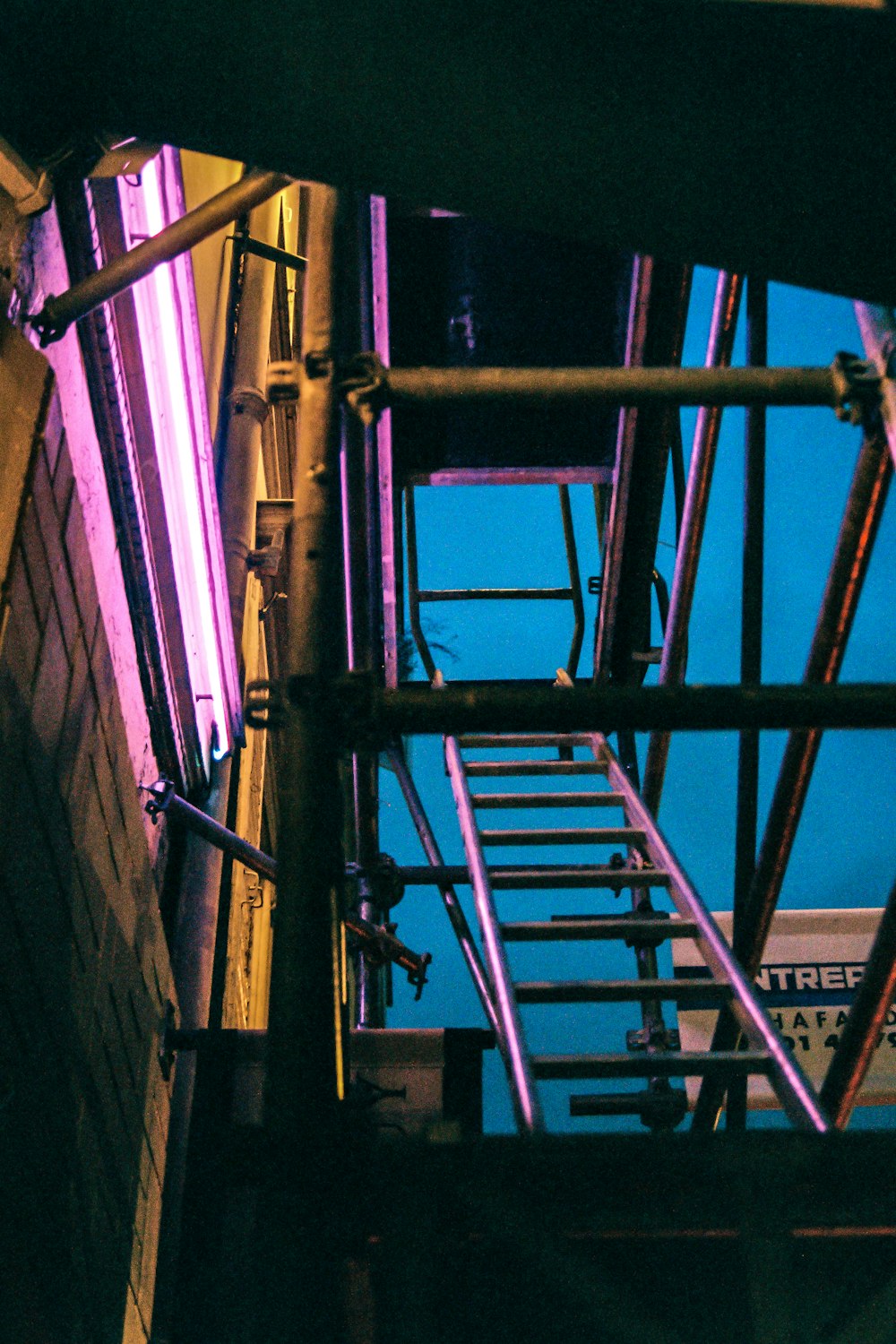 red metal ladder on brown wall