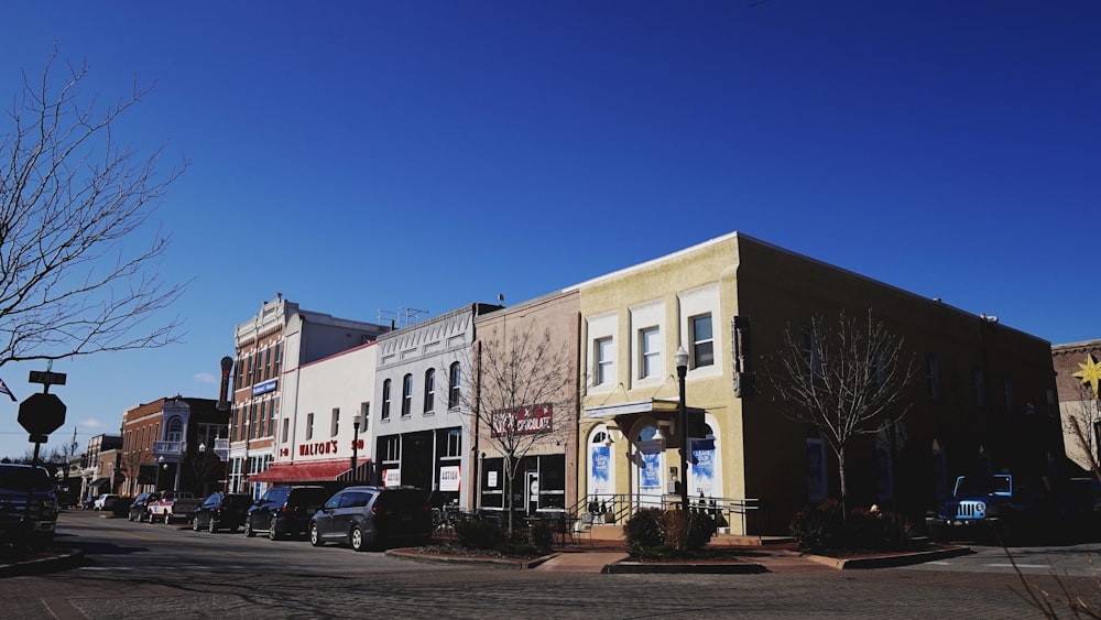 cars parked in front of white concrete building during daytime