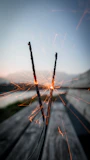Spark plugs lined up on a wooden surface with a soft focus background