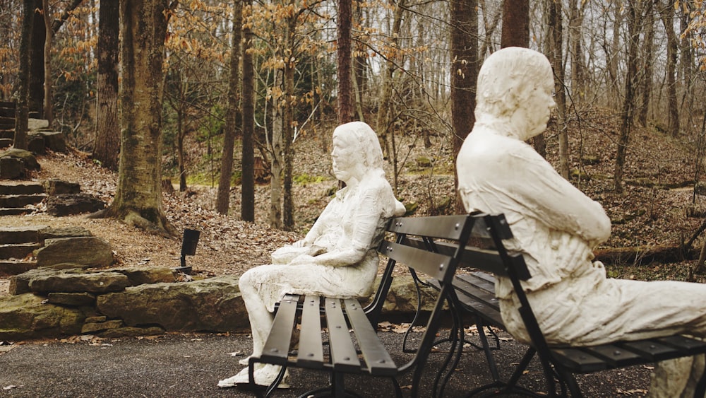 person in white hoodie sitting on black wooden bench