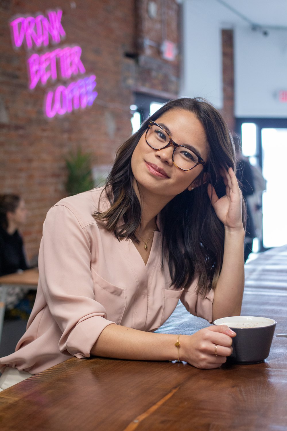 woman in beige button up shirt wearing black framed eyeglasses