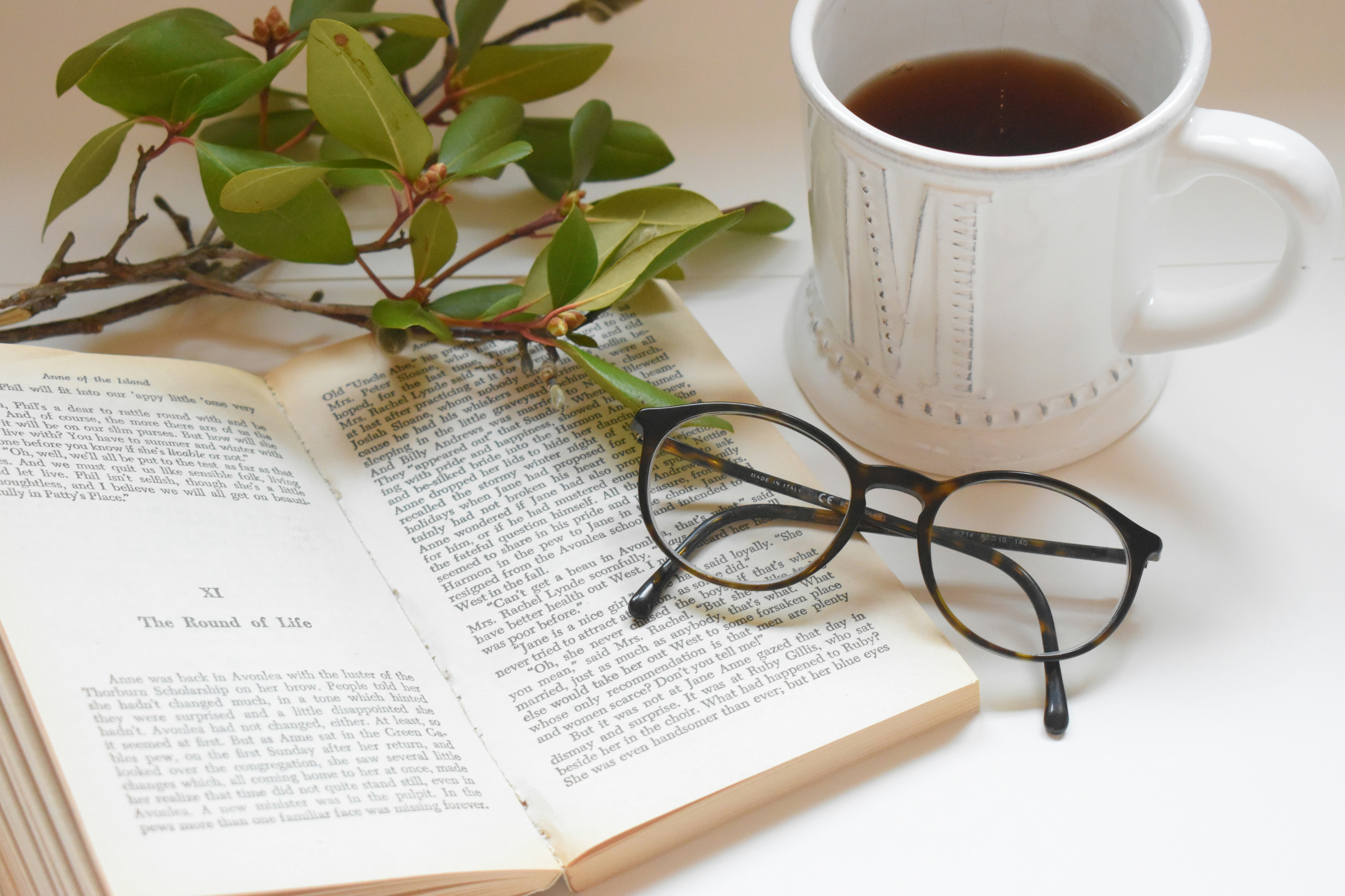 A book with a cup of coffee and glasses