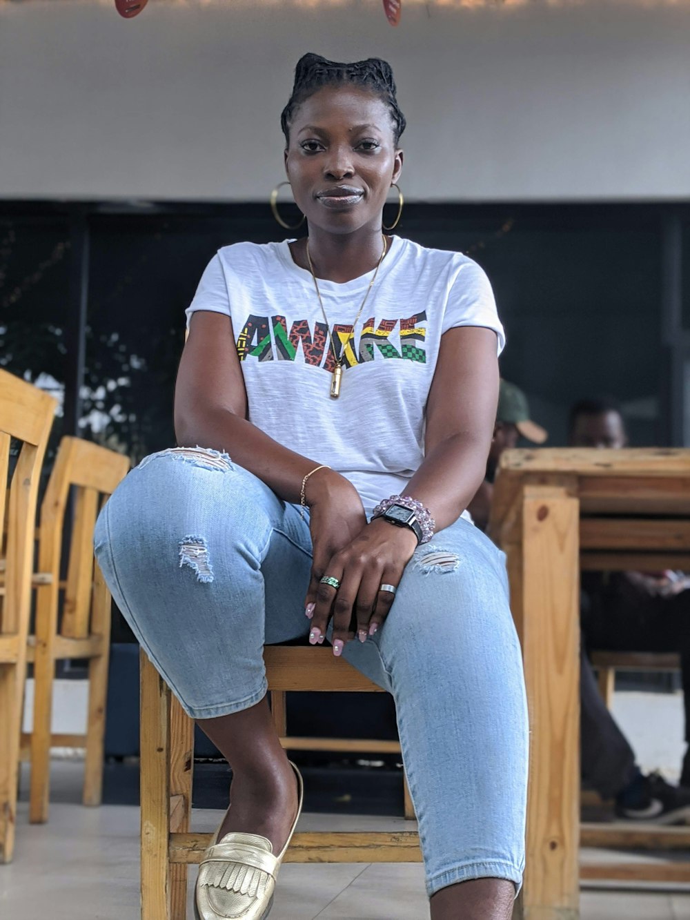 girl in white and blue crew neck t-shirt and blue denim jeans sitting on brown