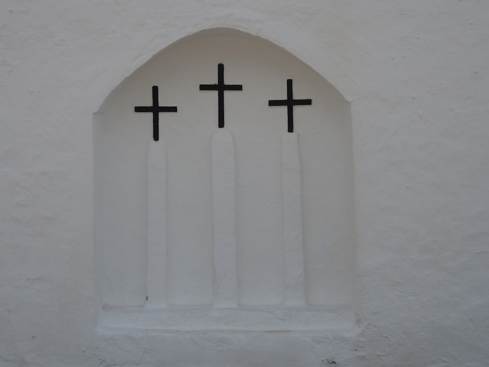 Croix blanche sur mur de béton blanc