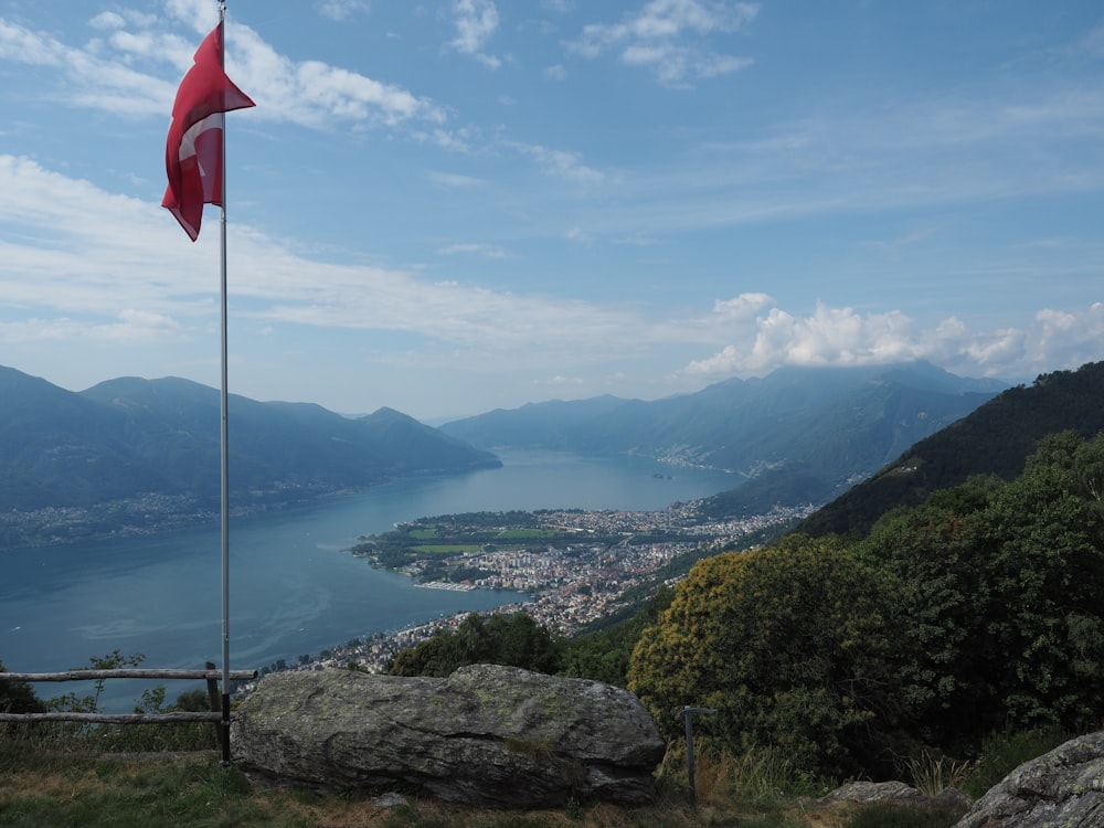 drapeau rouge et blanc sur le poteau au sommet de la montagne pendant la journée