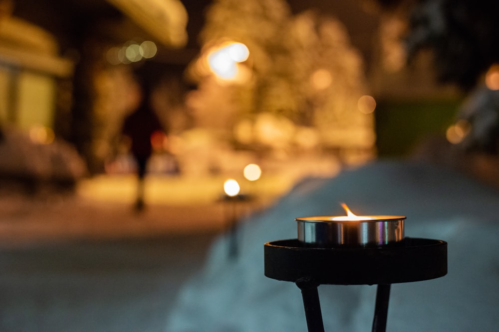 lighted candle in black holder