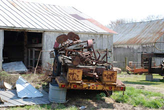 Rustic barn backdrop with several pieces of agricultural equipment lined up